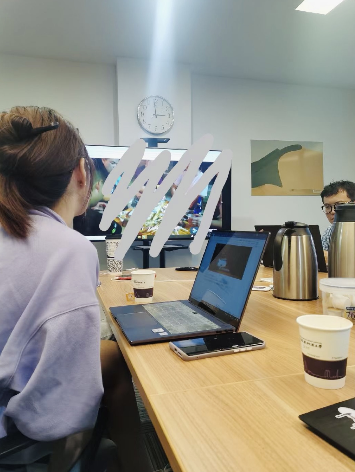 Reviewing documentary footage on a laptop in a meeting room during the edit